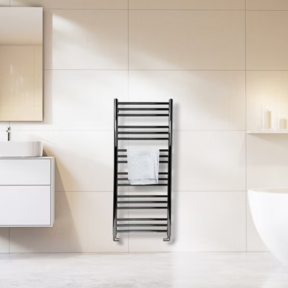 Lifestyle image of the Radox Salento 1210mm Chrome Heated Towel Rail mounted on a tiled bathroom wall, in between a vanity unit and freestanding bath